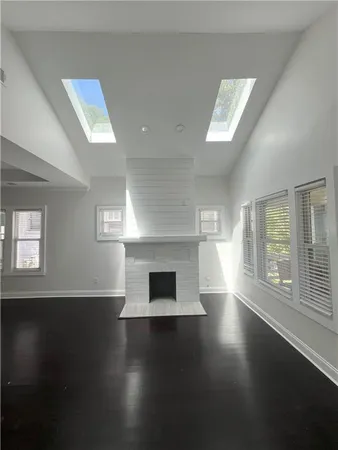 an empty room with windows and fireplace