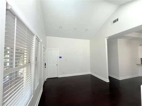 a view of empty room with wooden floor
