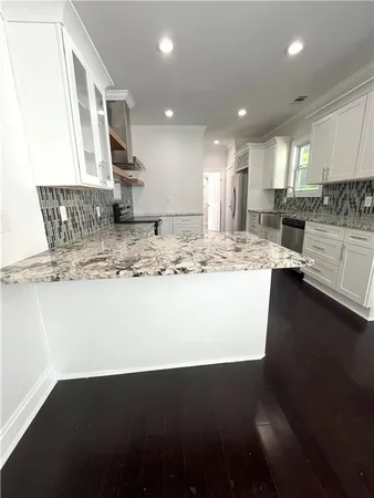a view of a kitchen with kitchen island stainless steel appliances
