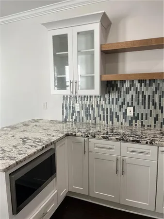 a kitchen with granite countertop white cabinets and white appliances