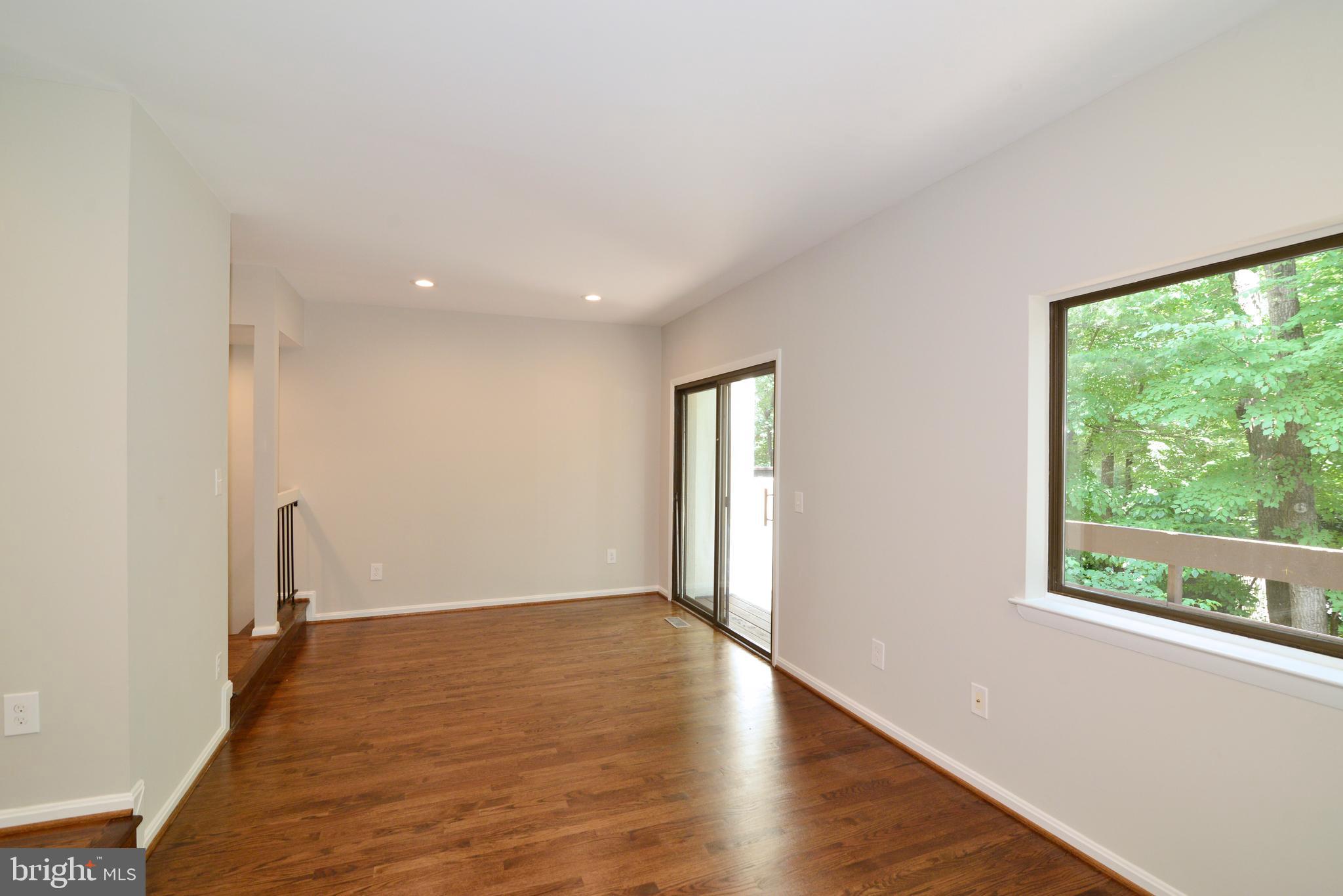 11803 Coopers Court Reston, VA 20191 - Photo 10 of 38 NEW HARDWOODS LEAD OUT TO DECK OVERLOOKING TREES