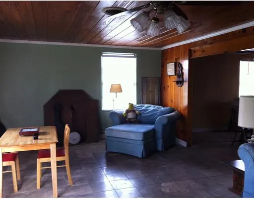 a living room with furniture a ceiling fan and a window