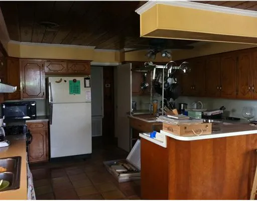 a kitchen with sink a refrigerator and cabinets