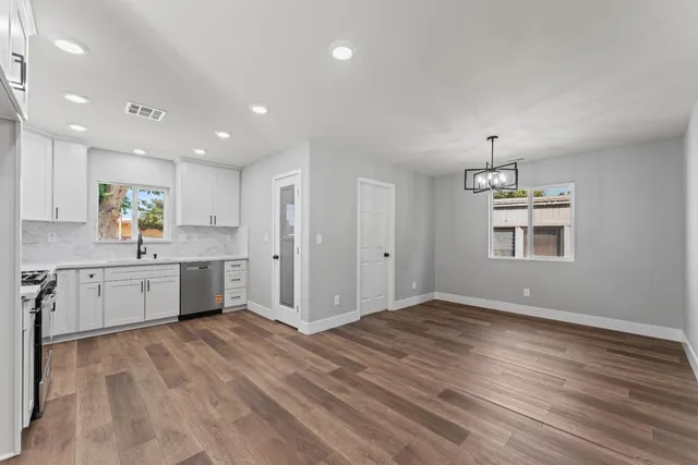a view of kitchen with wooden floor electronic appliances and window