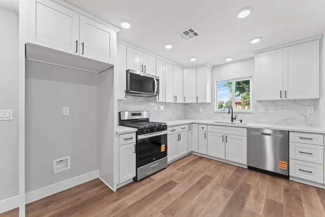 a kitchen with granite countertop appliances cabinets and a sink