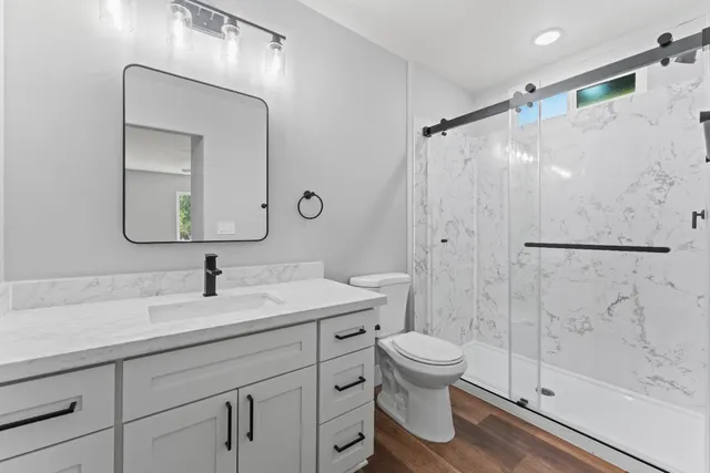 a bathroom with a sink a toilet and shower