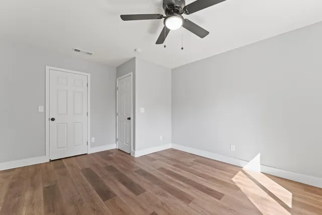 a view of empty room with wooden floor