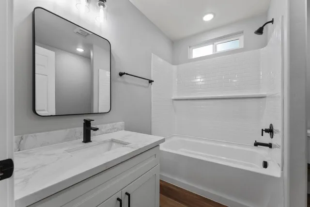 a bathroom with a sink a large mirror and shower