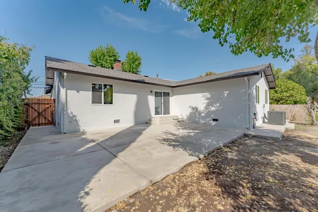 a view of a white house with a yard and plants