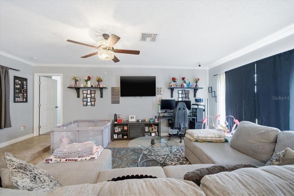 4464 Bromley Avenue Spring Hill, FL 34609 - Photo 12 of 43 a living room with furniture and a flat screen tv