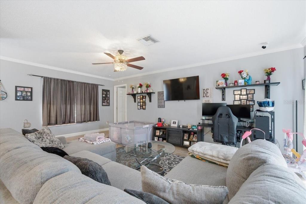 4464 Bromley Avenue Spring Hill, FL 34609 - Photo 13 of 43 a living room with furniture and a flat screen tv