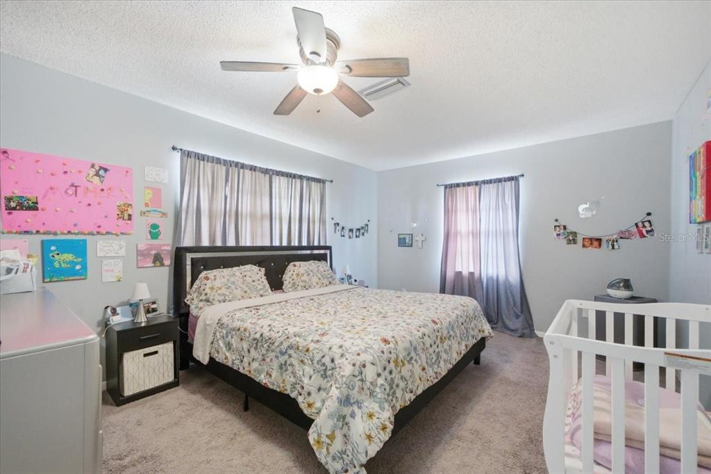 4464 Bromley Avenue Spring Hill, FL 34609 - Photo 26 of 43 a bedroom with a bed and a chandelier