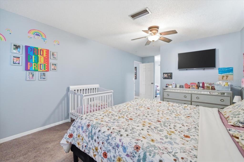 4464 Bromley Avenue Spring Hill, FL 34609 - Photo 27 of 43 a bedroom with a bed and a flat screen tv