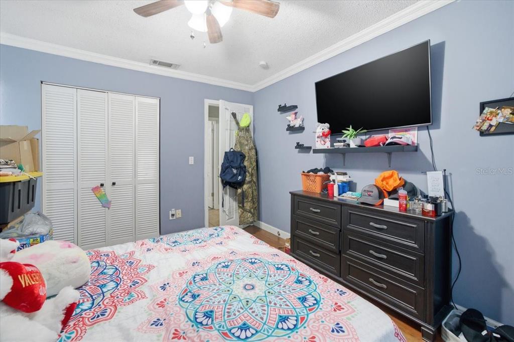 4464 Bromley Avenue Spring Hill, FL 34609 - Photo 36 of 43 a bedroom with a bed and a flat screen tv