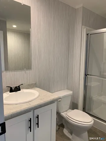 a bathroom with a sink a toilet and shower