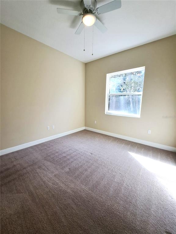 6 Parkview Circle Palm Coast, FL 32137 - Photo 16 of 32 an empty room with a chandelier fan and windows