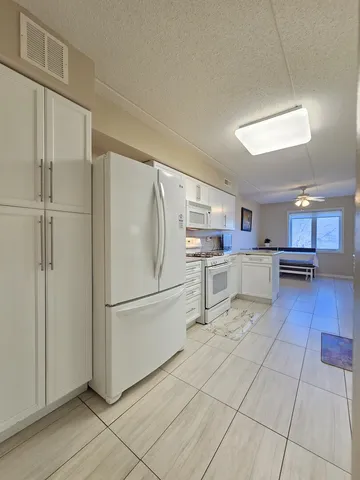 a kitchen with stainless steel appliances granite countertop a refrigerator and a stove top oven