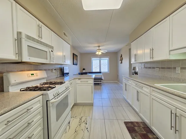a kitchen with stainless steel appliances a sink dishwasher stove refrigerator and cabinets
