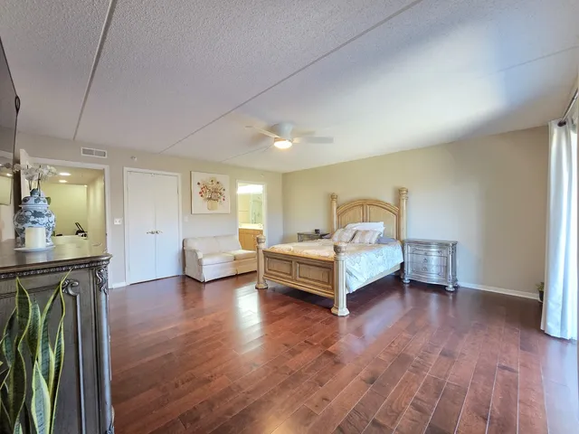 a spacious bedroom with a bed and wooden floor