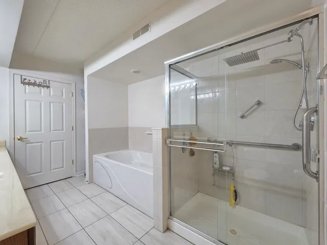 a bathroom with a tub shower vanity and a sink