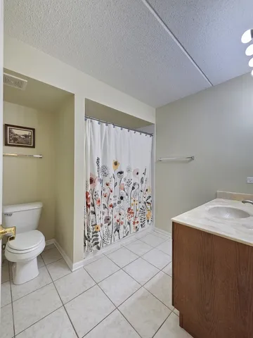a bathroom with a toilet and a shower curtain