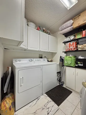 a utility room with cabinets washer and dryer