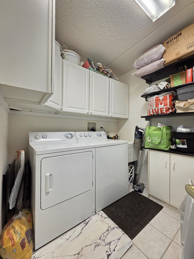 6815 North Milwaukee Avenue, Unit 210 Niles, IL 60714 - Photo 43 of 47 a utility room with cabinets washer and dryer