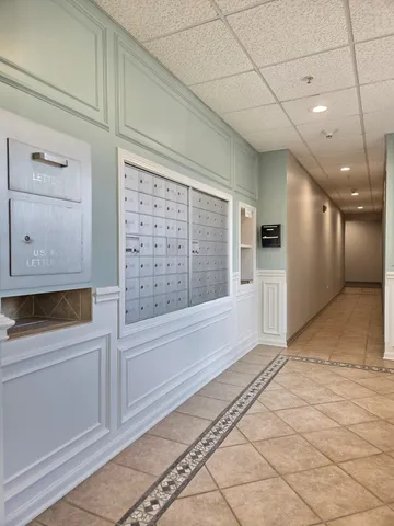 a view of a hallway with wooden floor and cabinet