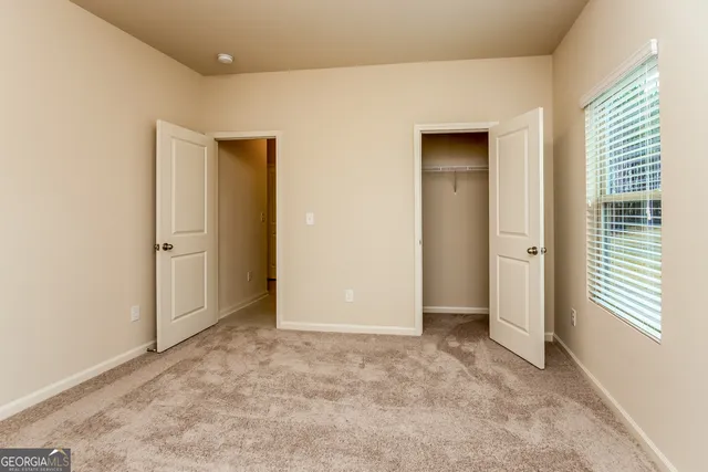 an empty room with windows and closet