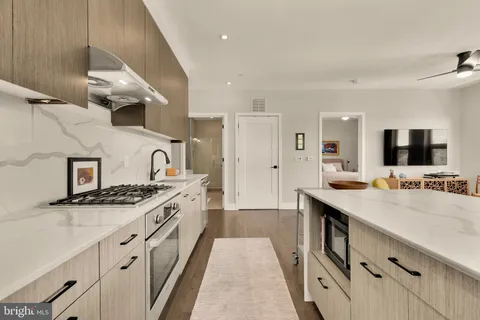 a large kitchen with stainless steel appliances granite countertop a stove and a sink