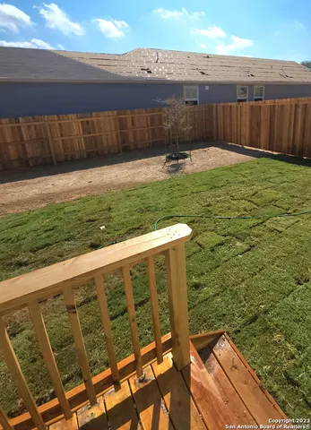 a view of a backyard with wooden fence