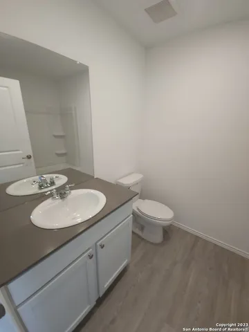 a bathroom with a granite countertop toilet a sink and a mirror