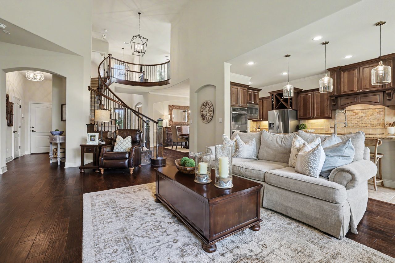 809 Prairie Dunes Drive Georgetown, TX 78628 - Photo 9 of 40 An inviting open-concept living space transitions gracefully from a cozy seating area to a chef's kitchen, all beneath high ceilings.
