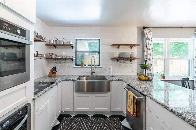 a kitchen with stainless steel appliances granite countertop a sink stove and cabinets