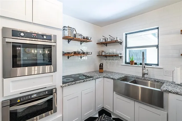 a kitchen with granite countertop cabinets stainless steel appliances and a sink