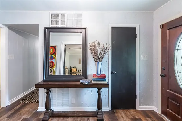 a living room with a mirror and a wooden floor