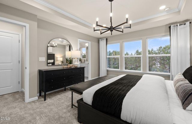 a bed sitting in a spacious bedroom next to a window