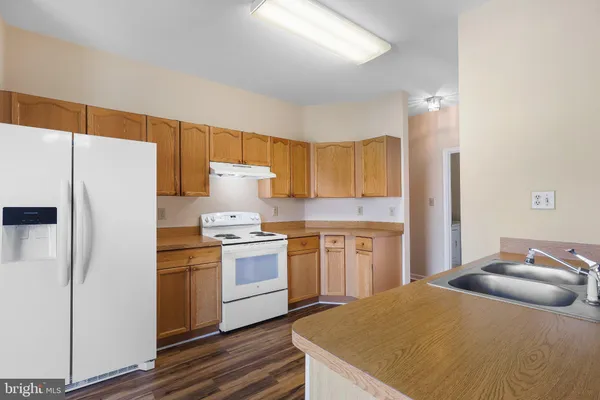 a kitchen with a refrigerator a stove top oven a sink and dishwasher