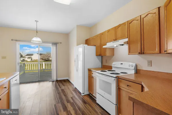 a kitchen with a stove a refrigerator and a wooden floors