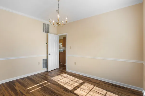 a view of an empty room with chandelier and a window