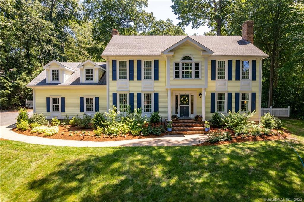 a front view of a house with yard and green space