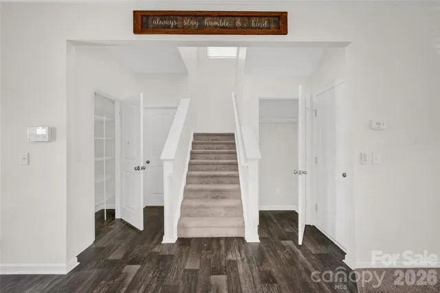 a view of a hallway with wooden floor and entryway