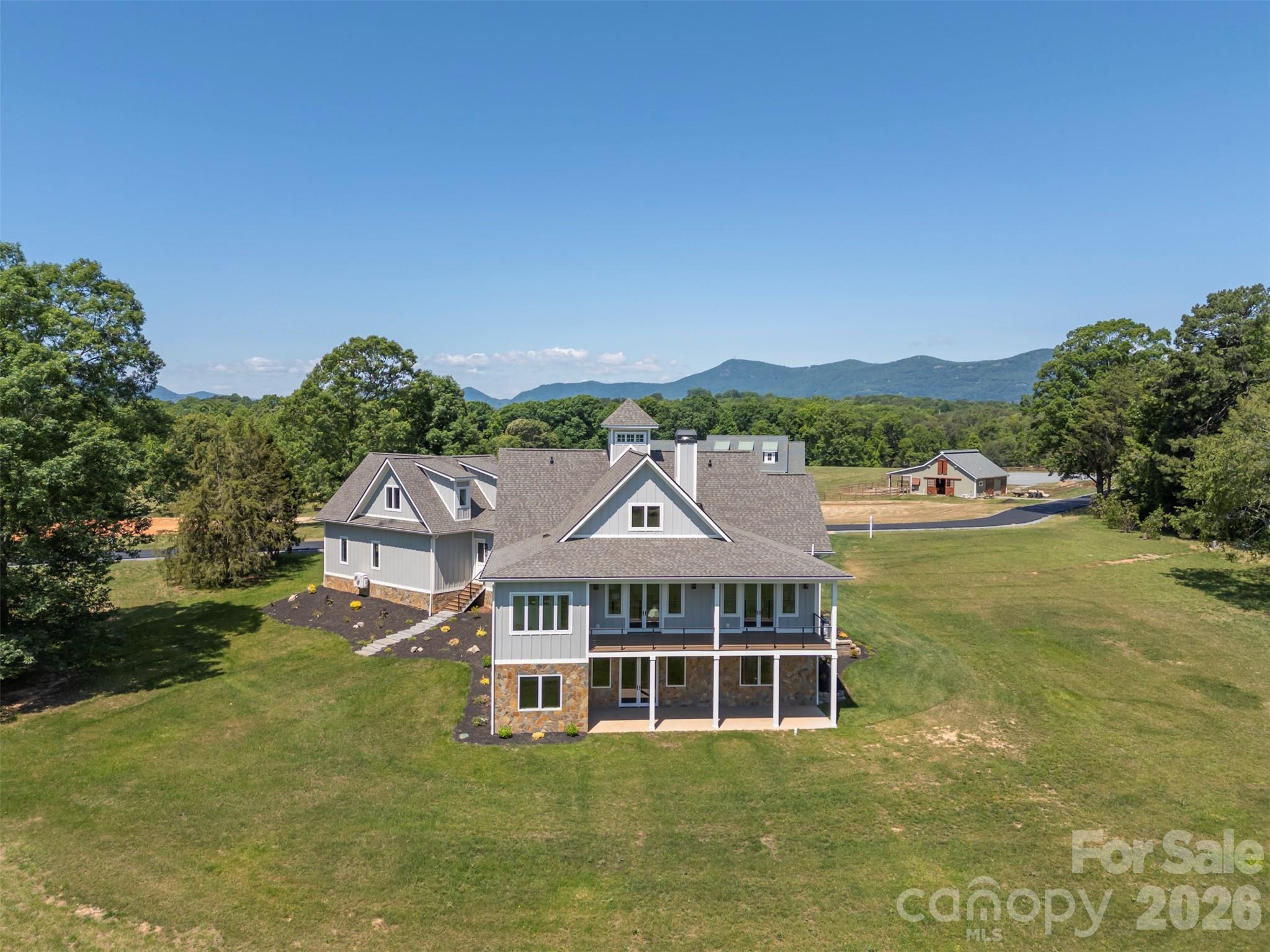 297 Mountain Meadows Lane, Unit 7 Tryon, NC 28782 - Photo 43 of 47 a view of a big house with a big yard and large trees