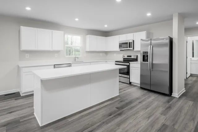 a kitchen with a refrigerator sink and cabinets