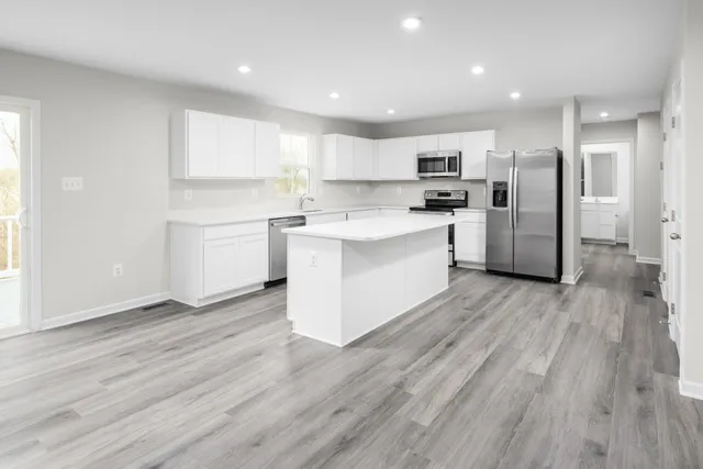 a kitchen with stainless steel appliances a refrigerator a sink dishwasher and a stove top oven