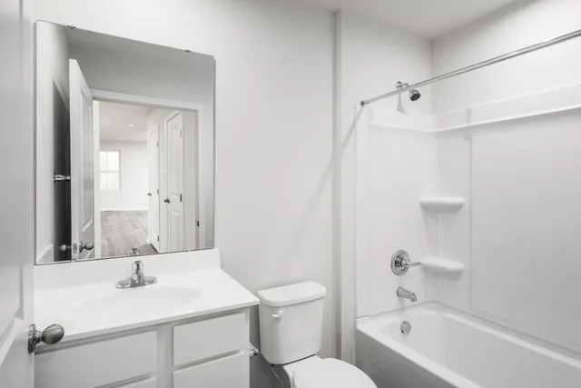 a bathroom with a sink toilet vanity and shower
