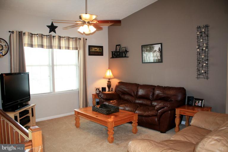 73 Haverhill Road Joppa, MD 21085 - Photo 25 of 30 a living room with furniture a chandelier and a flat screen tv