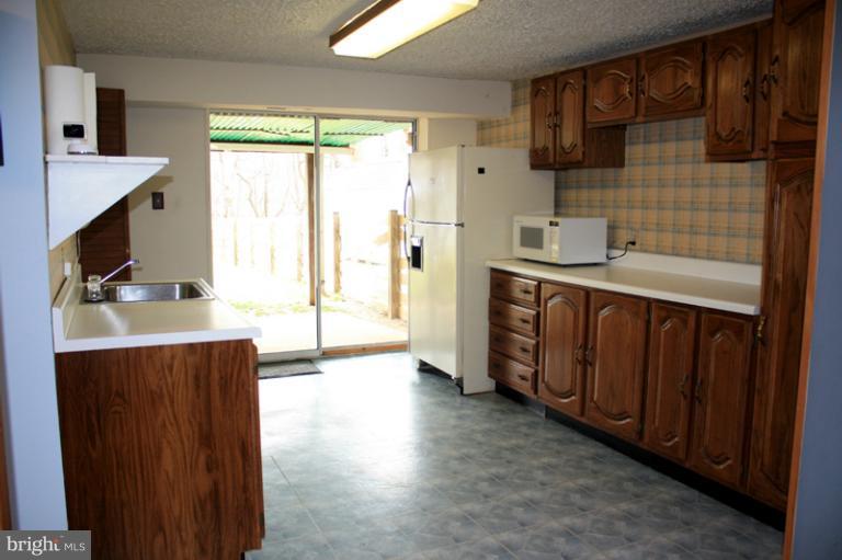 73 Haverhill Road Joppa, MD 21085 - Photo 9 of 30 a kitchen with stainless steel appliances a sink cabinets and a wooden floor
