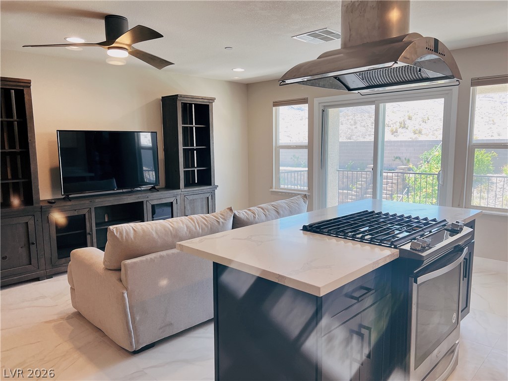 4631 Amazing View Street Las Vegas, NV 89129 - Photo 33 of 33 An open floorplan seamlessly connects the kitchen with a gas cooktop island to the sun-filled living area.