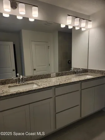 a kitchen with granite countertop white cabinets and stainless steel appliances